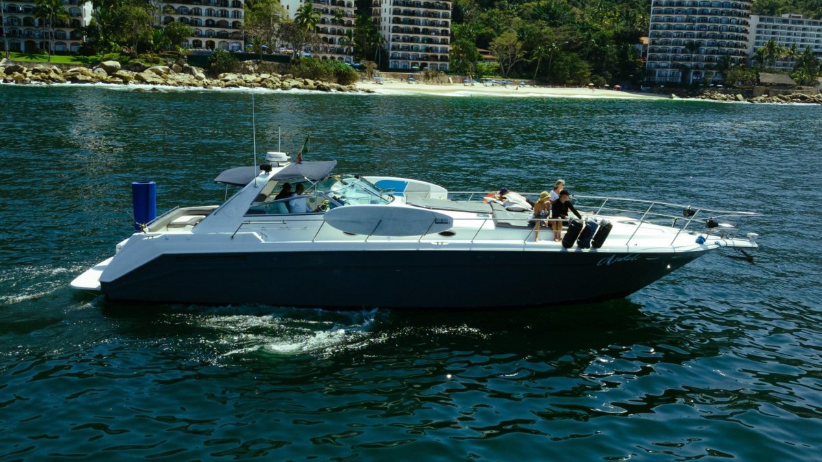 Sea Ray 50 Sundancer yacht rental on Banderas Bay with the Puerto Vallarta coastline behind